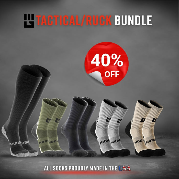 Five MudGear tactical and ruck socks in black, gray, olive, and tan colorways displayed standing upright