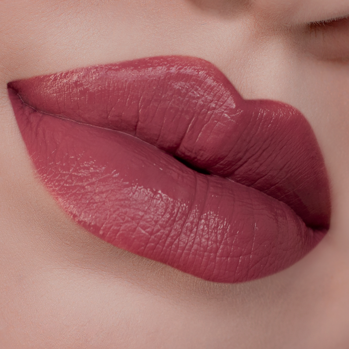 Blush rosy mauve lipstick on lips, light skin tone close-up